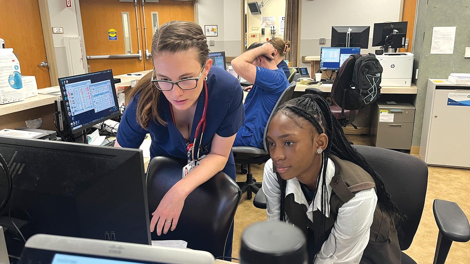 A doctor showing a young lady something on a computer