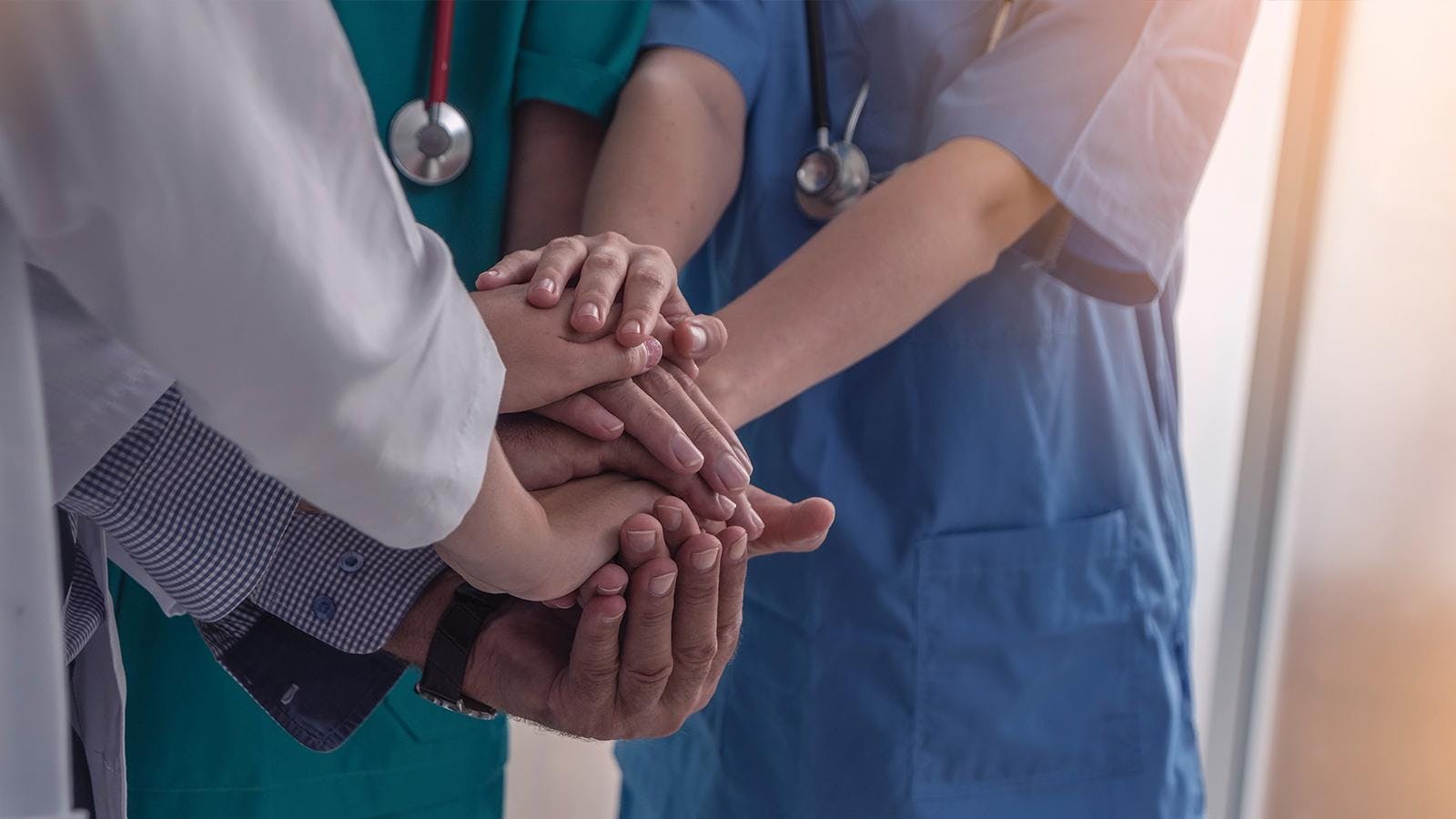 A group of doctors putting their hands together